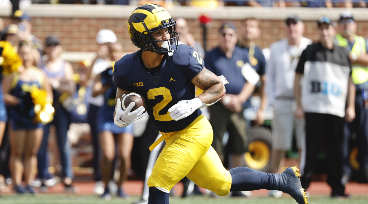Michigan RB Blake Corum runs with the ball while looking behind him
